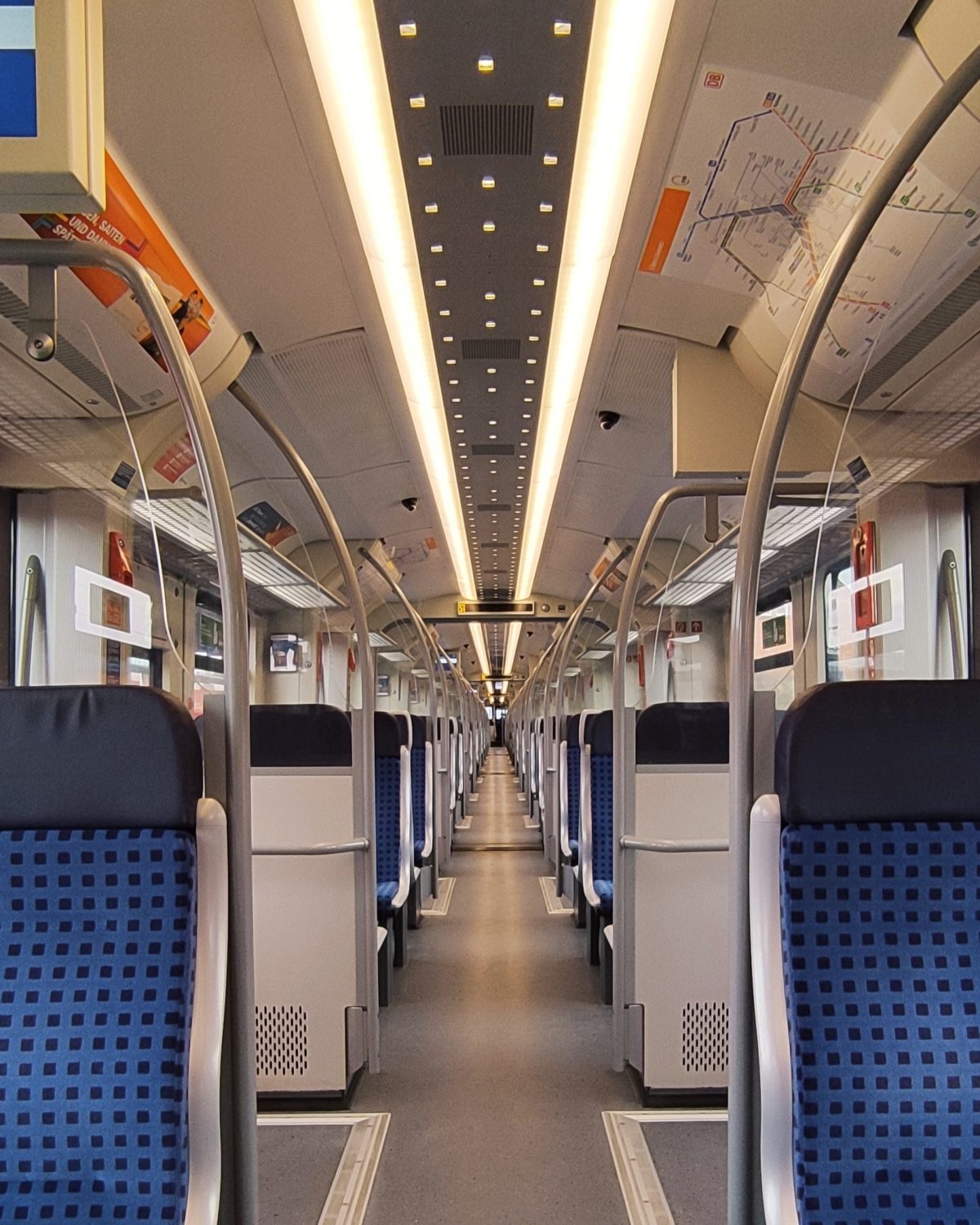 Der Innenraum eines leeren Regionalzuges der Deutschen Bahn mit Blick den Gang hinunter