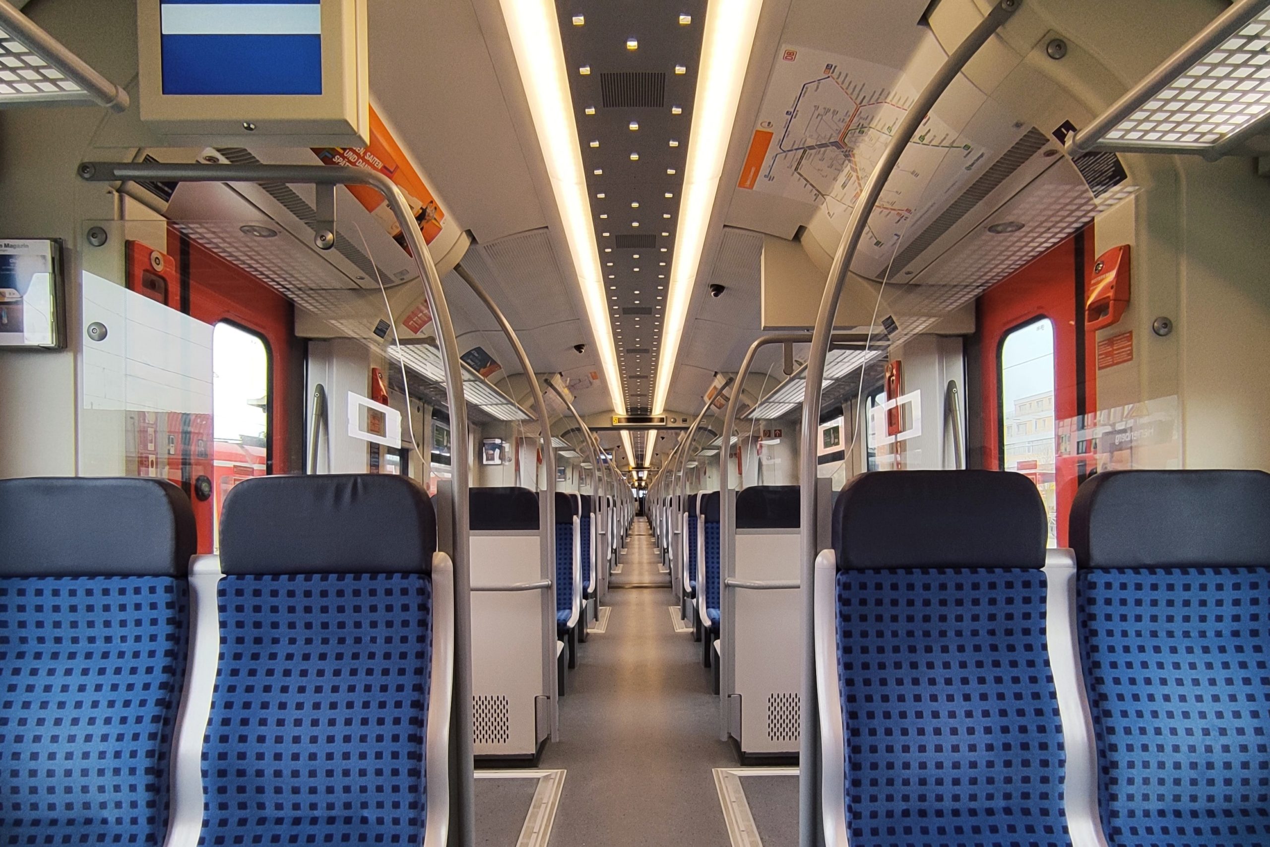 Der Innenraum eines leeren Regionalzuges der Deutschen Bahn mit Blick den Gang hinunter
